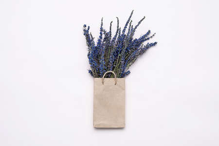 Paper shopping bag with dried flowers bouquet. Autumn gift sales concept.の写真素材