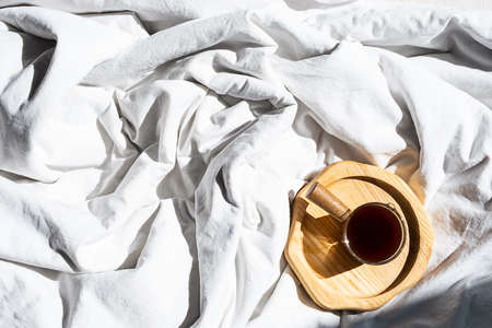 Cozy homely scene with coffee cup in bed. Morning concept.の写真素材