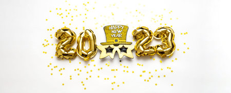 2023 number made from golden balloons and carnival mask. happy new year concept.
