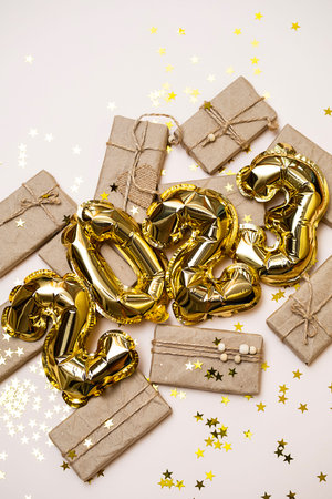 2023 number made from foil golden balloons and gift boxes. new year background.