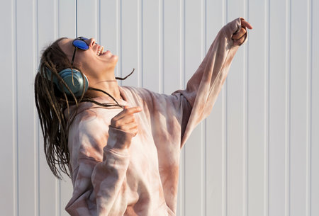 Dreadlock woman listening to music in headphones.の写真素材
