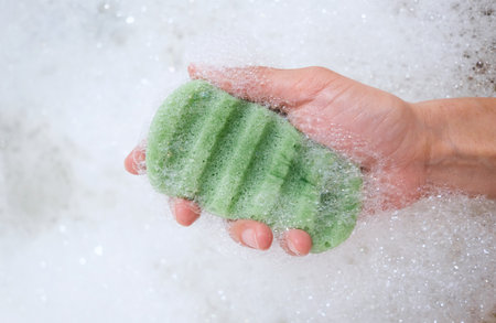 Konjac sponge with foam bubbles in female hand, close up. Zero waste product.の写真素材