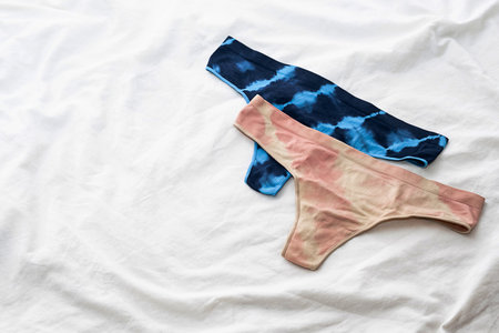 Two female panties on white bedding. Flat lay with daily underwear.の写真素材