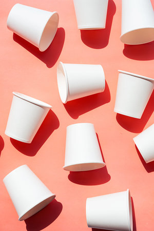 Several disposable white paper cups. Mock up to go coffee cups with shadows on pink.の写真素材