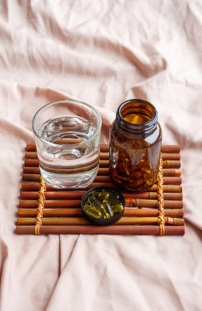 Omega 3 oil capsules and water glass on tray. Fatty acids nutritional supplement for health support.の写真素材