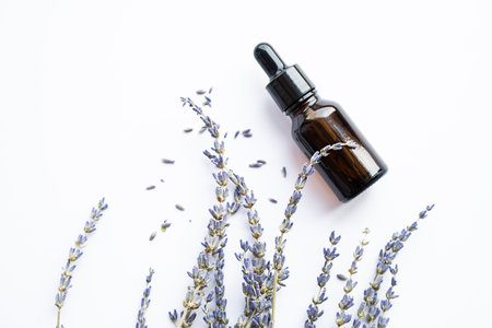 Essential lavender oil drop bottle and dried lavender flowers. Skin care organic product.の写真素材