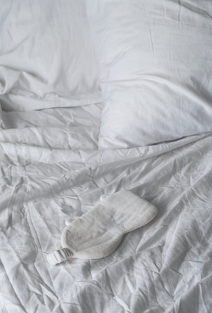 Sleep eye mask lying on white bedding. Awaking or insomnia concept.の写真素材