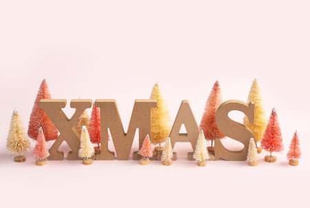 Christmas time still life. Artificial tiny Christmas trees and wooden XMAS word.の写真素材