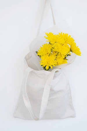 Freshly yellow flowers in eco tote bag. Springtime come in.の写真素材