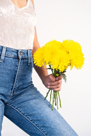 Anonymous woman holding yellow flowers.の写真素材