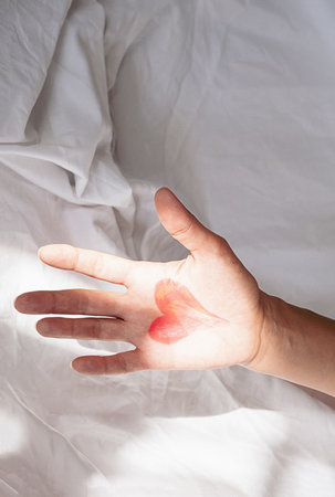 Palm of hand in bed at the morning. Valentines day concept.