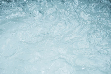 Turbulent water surface with visible foam and ripples.の写真素材