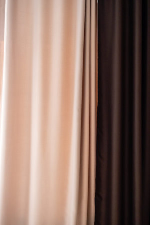 Beige and brown curtains with soft shadows, showing their texture and folds.の写真素材