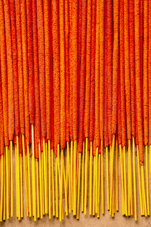 Orange incense sticks are neatly arranged on paper background. Relaxation and spirituality concepts.の写真素材