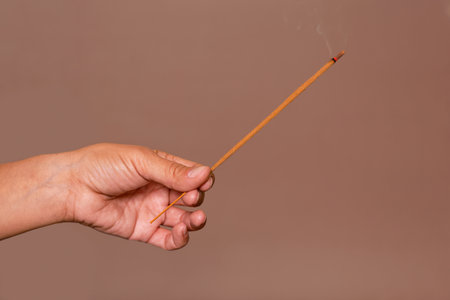 Hand holding burning incense stick. Relaxation and mindfulness concepts.の写真素材