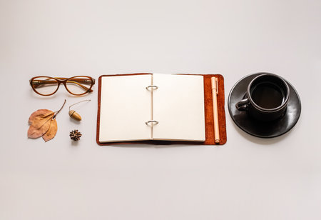 Minimalist workspace with open notebook, glasses and coffee cup.の写真素材