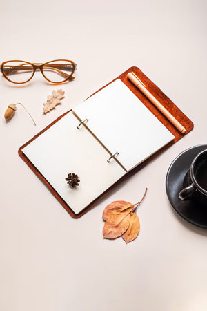 Minimalist workspace with open notebook, glasses and coffee cup.の写真素材