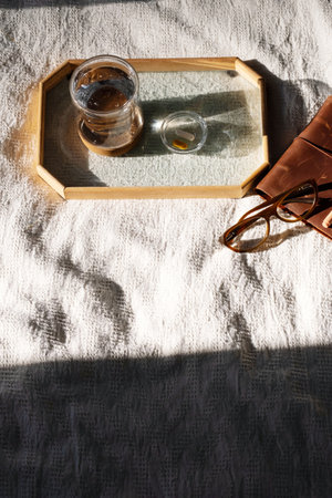 Glass of water, vitamin supplement dose, notebook and eyeglasses on tray. Morning still life.の写真素材