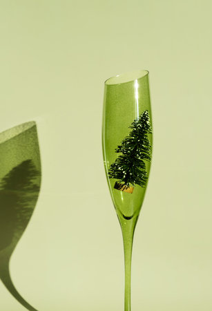 Green champagne glass with miniature Christmas tree inside.の写真素材