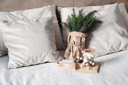 Rustic decor with fir branches in paper bag, festive latte with marshmallows. Cozy xmas morning concept.の写真素材