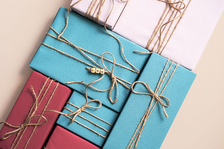 Colorful gift boxes tied with rustic twine, displayed on beige background