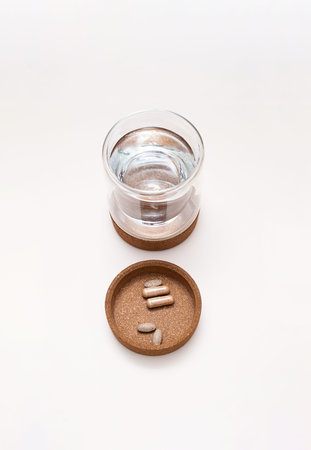 Vitamin capsules and glass of water. Medical still life.の写真素材