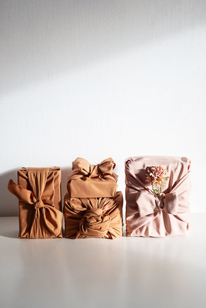 Gift boxes wrapped in reusable fabric, promoting waste reduction and sustainable gifting ideas.の写真素材