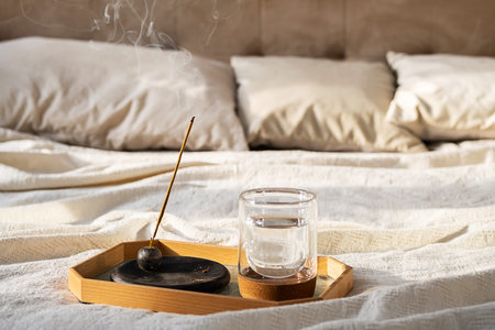 Morning Calm, Smoldering Aromatherapy Incense and Glass of Water on Tray by Bed.