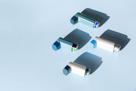 Emergency Asthma Inhalers on Cool Blue Background in Hard Lighting. Medical Health Concept.の写真素材