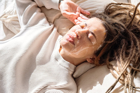 Woman Having Facial Mask While Resting On Bed.
