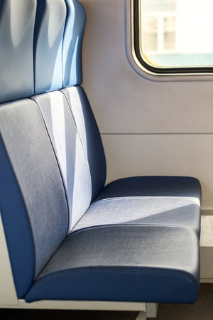 Empty Blue Seat Inside the Train Car with Sunlight from the Window.の写真素材