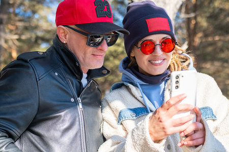 Woman and Man Using Smartphone for Social Media in Casual Style in Outdoor Setting.