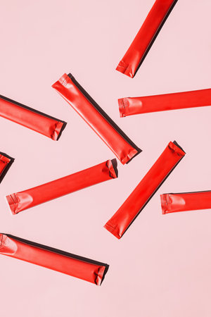 Powder Packets are Scattered on Pink Background. Nutritional Supplement or Medication Distribution Concepts.の写真素材