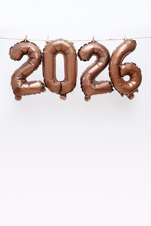 Bronze 2026 Balloons Hang from String with Clothespins. New Year Celebration Concept for Greeting Card, Calendar or Party Decor.の写真素材