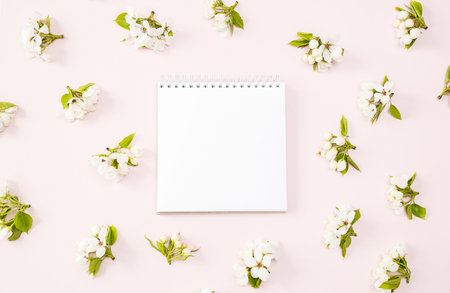 Blank Notebook Surrounded by White Flowers. Springtime Ideas and Inspiration Concept.の写真素材