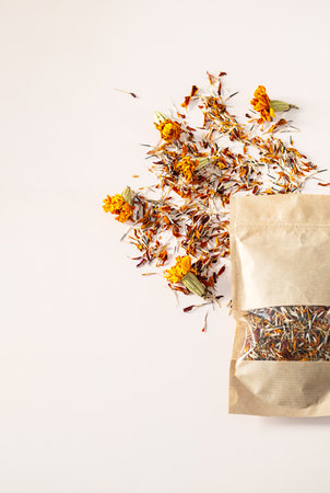 Dried Marigold Petals and Whole Flowers Scattered Next To an Open Craft Paper Bag, Top View with Copy Space.の写真素材
