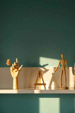 Wooden Mannequin and Hand with Flower on Shelf. Interior Decor for Artists and Designers Studio Space.の写真素材