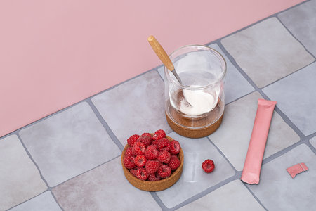 Collagen powder in glass with raspberries for health and beauty. Dietary supplement for skin, hair and nail support.の写真素材