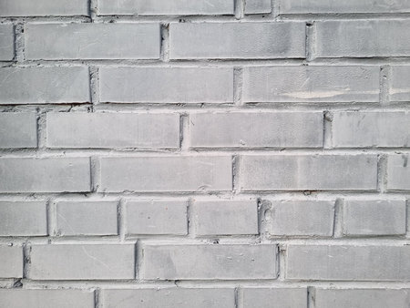 Light gray brick wall texture with rough surface. Full frame background for a construction concept.