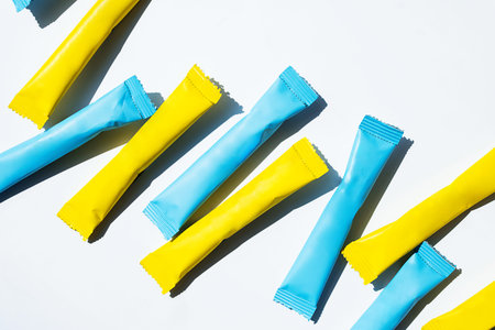 Yellow and blue stick pack energy drink and instant coffee mockup. Individual serving sugar sachet...