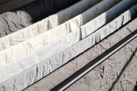 Clean dry laundry on clothes horse in rows, showcasing simple and ecofriendly household chore. Sustainable living or domestic scene concept.の写真素材