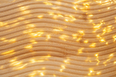 Golden abstract light pattern on wooden surface. Illuminated textured wood background. Natural...