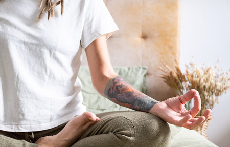 Woman in yoga position at home. Female practicing meditating on peaceful morning. Digital detox...
