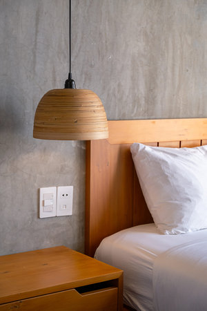 Cozy bedroom detail with wooden lampshade and concrete wall. Modern minimalist interior design for...