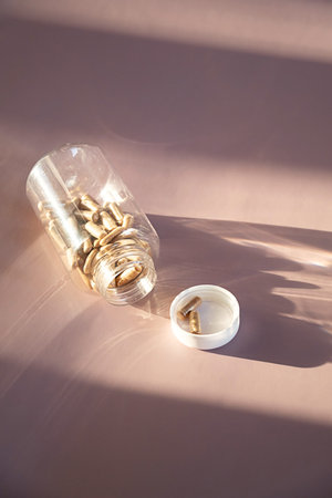 Spilled medical capsules from clear bottle with lid. Concept of health, wellness and pharmaceutical product.の写真素材