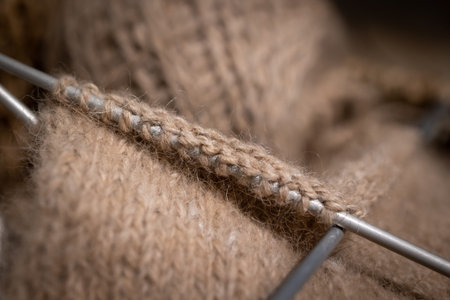 Knitting beige wool yarn. Set of loops close-up