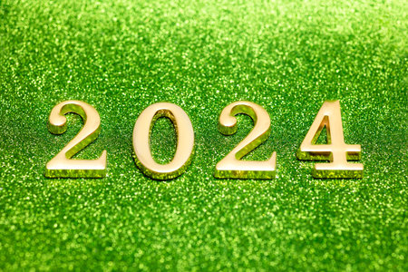 New calendar year 2024: symbols of letters in gold color on a shiny green background