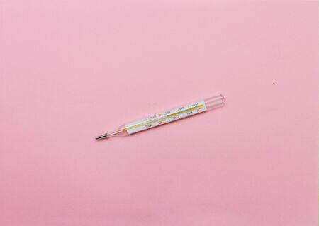 mercury thermometer on a pink backgroundの写真素材