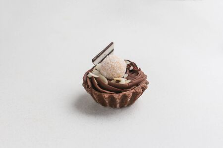 Tasty chocolate cupcake with coconut on white backgroundの写真素材