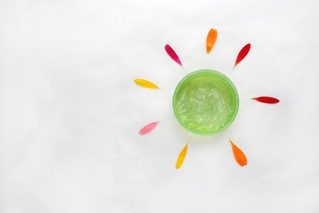 Jar of cream and flowers on white background, top view. Professional cosmetic productsの写真素材